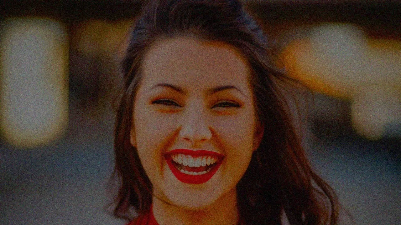 Portrait of a smiling woman taken in low light — Before